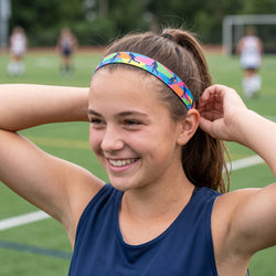 Woman adjusting a colorful headband on a sports field