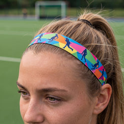 Colorful headband with sports-themed design on a person's head against a blurred sports field background