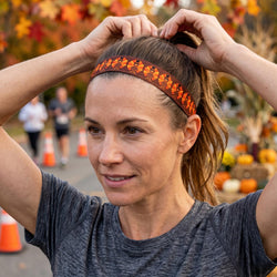 Woman adjusting her turkey themed headband with a festive background