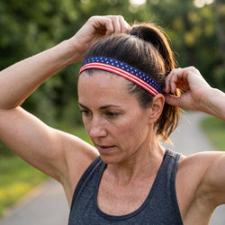 Woman adjusting an american themed  headband outdoors with a blurred natural background