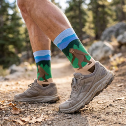 Man wearing bigfoot themed socks on a trail