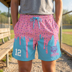 Person wearing pink and blue shorts with a tiger logo and number 12, standing outdoors.