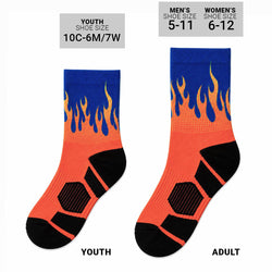A pair of crew socks with a flame pattern in blue, yellow, and orange, featuring black textured panels on the sole.