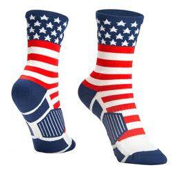 A pair of crew socks featuring an American flag design with white stars on a navy blue cuff, red and white stripes, and navy blue heel, toe, and sole sections, shown against a plain white background.