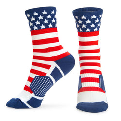 A pair of crew socks with an American flag pattern, featuring a navy blue cuff with white stars, red and white stripes, and navy blue heel and toe sections, shown against a plain white background.