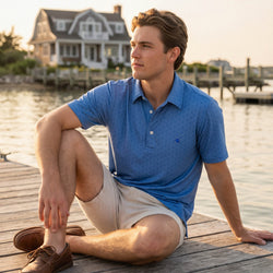 Teen wearing a blue hockey patterned polo shirt outdoors at a pier.