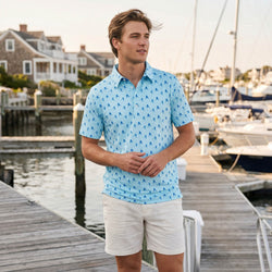 Teen wearing a hockey patterned polo shirt outdoors at a pier.