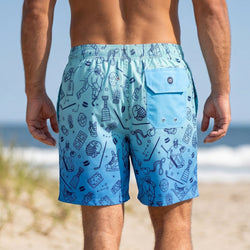Person wearing blue swim shorts with a hockey pattern on a beach