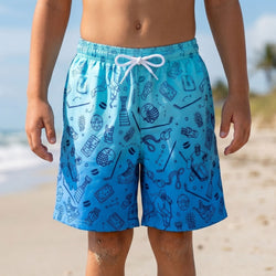 Person wearing blue swim shorts with a hockey pattern on a beach