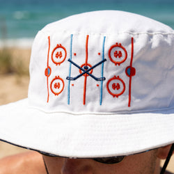 White bucket hat with red and blue hockey design on a beach