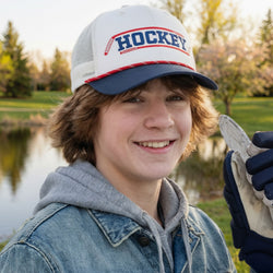 Youth wearing white hockey rope hat with blue rim