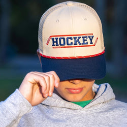 Person wearing a cap with 'HOCKEY' text and design, outdoors.
