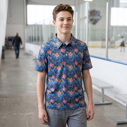 Person wearing a tropical themed polo shirt with hockey pattern worn in an indoor hockey rink.