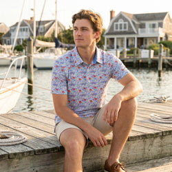Teen wearing a hockey patterned polo shirt outdoors at a pier.