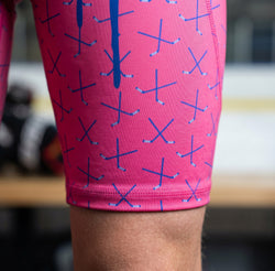 Pink shorts with blue hockey patterns worn by a person, blurred background
