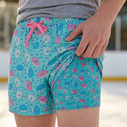 Person wearing turquoise shorts with donut pattern and pink drawstring.