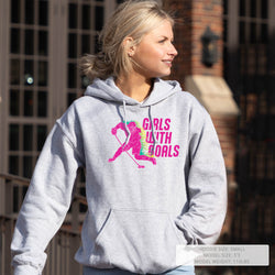 Woman wearing a gray hoodie with a colorful graphic and text, standing outdoors.