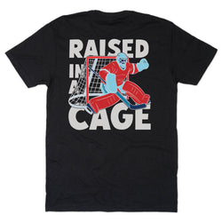 Black t-shirt with a graphic of a hockey goalie and text 'Raised in a Cage' on a white background