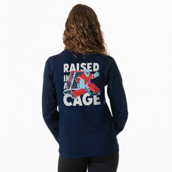 Navy long sleeve t-shirt with 'Raised in a Cage' graphic on the back, worn by a person.