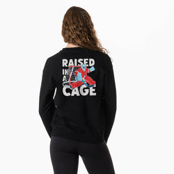 Person wearing a black sweatshirt with 'Raised in a Cage' graphic on the back