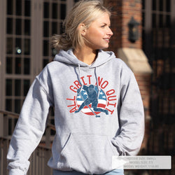 Woman wearing a gray hoodie with a hockey graphic design outdoors