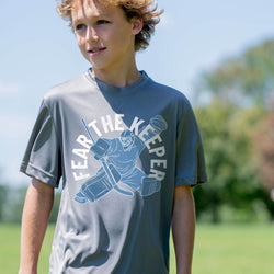 Child wearing a gray 'Fear The Keeper' t-shirt outdoors