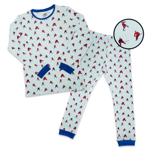 A two-piece kids' pajama set featuring a long-sleeve top and matching pants with an all-over hockey player print on a white background. The set has blue trim on the collar, cuffs, and pocket openings.