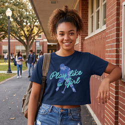 Young woman wearing a navy blue t-shirt with a hockey girl graphic and text, standing on a college campus.