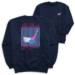 Navy blue sweatshirt with 'She Shoots, She Scores' hockey graphic on a white background