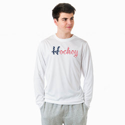 Person wearing a white long sleeve tee with a patriotic hockey script design