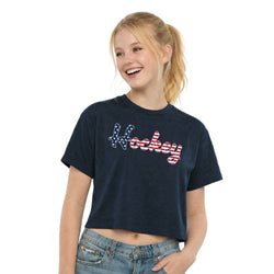 Girl wearing a navy blue t-shirt with 'Hockey' printed on it, standing against a white background