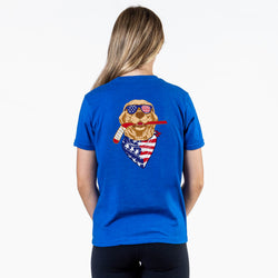 Person wearing a blue t-shirt with a graphic of a dog wearing sunglasses and an American flag bandana on the back.