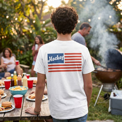 Person wearing a white t-shirt with an American flag hockey design at a barbecue party.