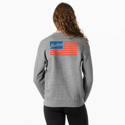 Person wearing a gray sweatshirt with a colorful hockey usa flag graphic on the back against a white background