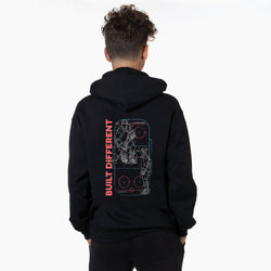 Person wearing a black hoodie with a hockey design and 'Built Different' text on the back against a white background