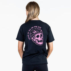 A woman viewed from the back wearing a black short-sleeve T-shirt with a large pink graphic on the back showing a skull in a hockey helmet and the words 'LEAVE IT ALL ON THE ICE'.