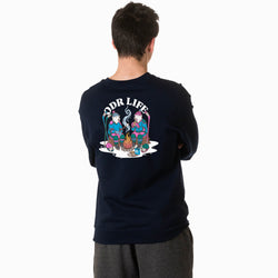 A person viewed from behind wearing a navy crewneck sweatshirt with a large colorful graphic on the back that reads 'ODR LIFE' and shows two illustrated figures around a campfire, paired with gray sweatpants against a plain white background.