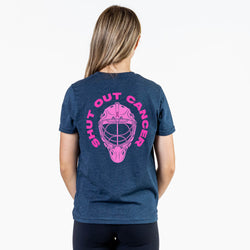 A woman viewed from the back wearing a heather navy blue t-shirt with a large pink graphic of a hockey goalie mask and the words 'SHUT OUT CANCER' printed on the back.