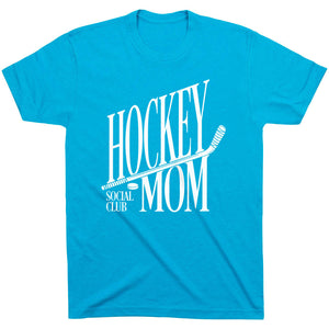 A bright turquoise blue short-sleeve crewneck t-shirt with a white graphic print on the front that reads 'HOCKEY MOM SOCIAL CLUB' with a hockey stick and puck illustration.