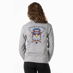 A woman viewed from behind wearing a heather gray long-sleeve shirt with a large patriotic hockey graphic on the back, paired with black leggings, against a plain white background.