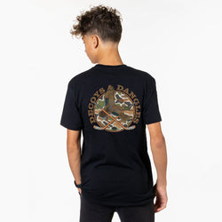 A boy shown from the back wearing a black t-shirt with a large graphic on the back. The graphic features the words 'DECOYS & DANGLES' in a tan font surrounding a camouflage circle with a duck and crossed hockey sticks.