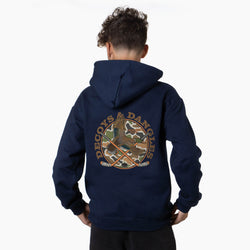 A boy viewed from behind wearing a navy sweatshirt with a large graphic on the back. The graphic features the words 'DECOYS & DANGLES' in a tan font surrounding a camouflage-patterned circle with a duck and crossed hockey sticks