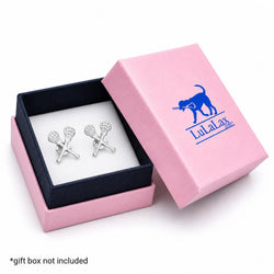 A pair of silver-toned crossed-lacquet cufflinks displayed inside an open pink gift box with a navy interior. The pink lid is propped beside the box and printed with a blue dog logo and the text 'LuLaLax'.