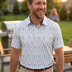 Man wearing a patterned lacrosse polo shirt standing outdoors with blurred background