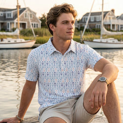 Teen wearing a lacrosse patterned polo shirt outdoors by a pier.