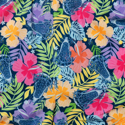 A close-up of a tropical floral and lacrosse patterned fabric, featuring bright pink, yellow, orange, and purple hibiscus flowers, green leaves, and blue lacrosse sticks on a dark navy background.