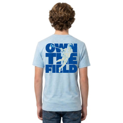 Person wearing a light blue t-shirt with 'Own the Field' graphic on the back
