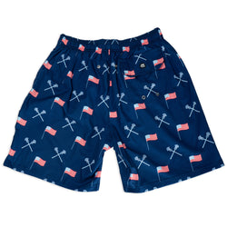 Navy swim shorts with American flag and lacrosse stick pattern on a white background