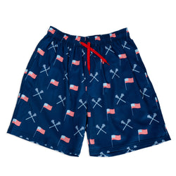Navy swim shorts with American flag and lacrosse stick pattern on a white background