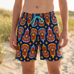 Person wearing colorful lacrosse patterned swim trunks on a beach.